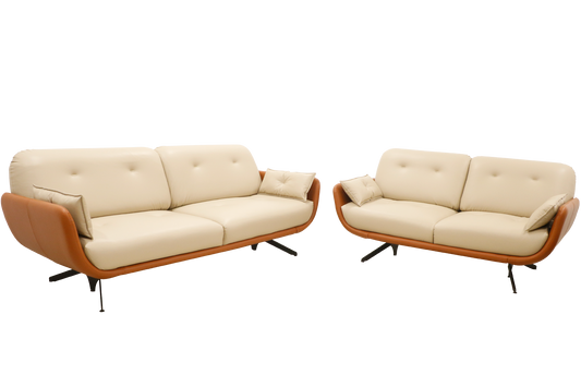 A stylish modern sofa with cream-colored cushions and a curved brown leather frame, featuring tufted backrests and angled black metal legs, isolated on a black background.