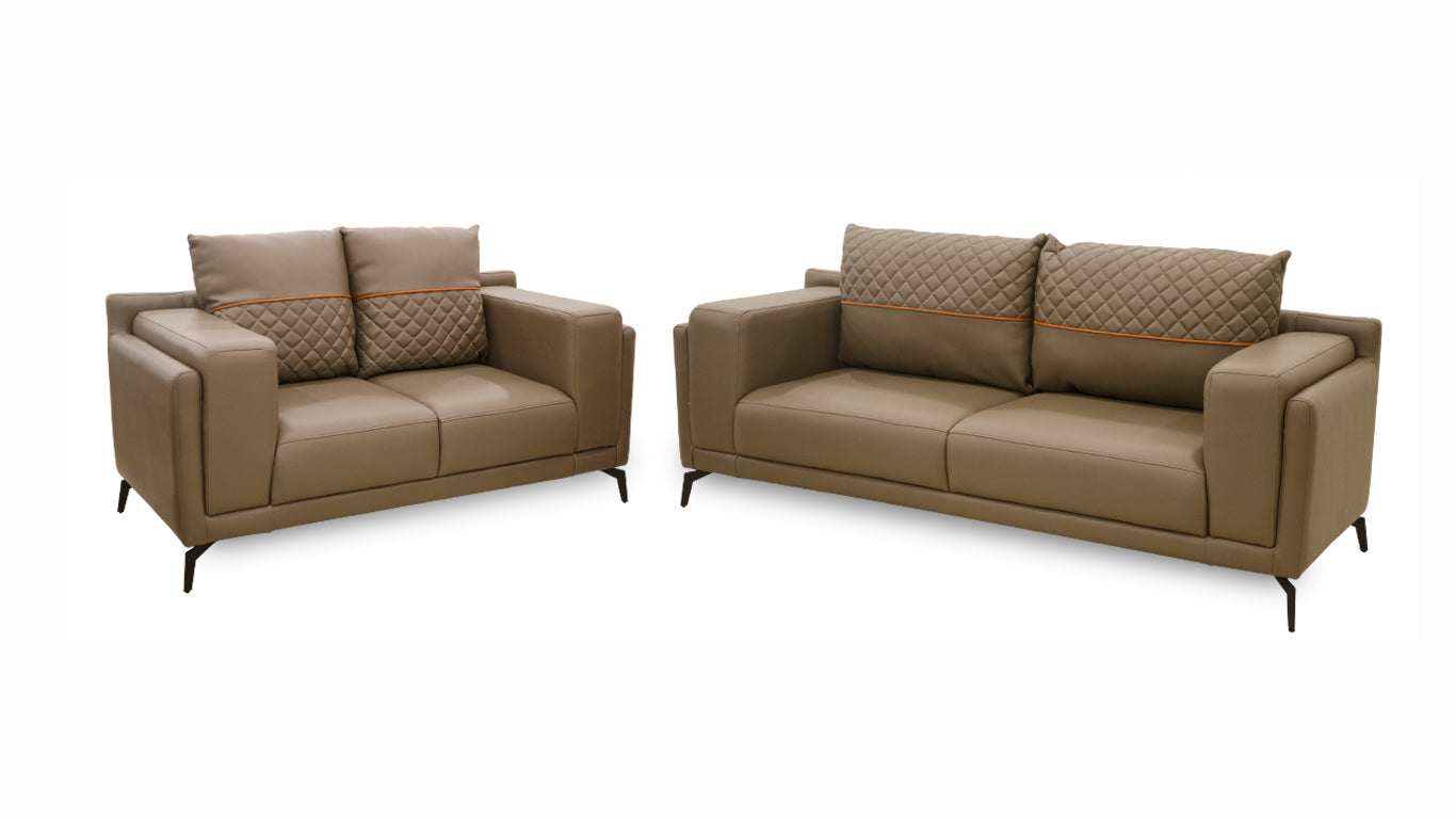  A pair of leather sofas featuring coordinated pillows and cushions, enhancing the comfort and aesthetic of the space.