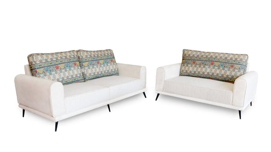 White modern sofa with patterned back cushions on a blue gradient background.